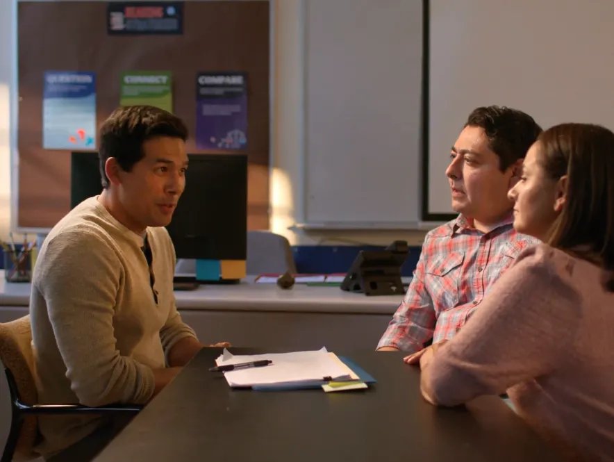 A teacher speaks with a student's parents