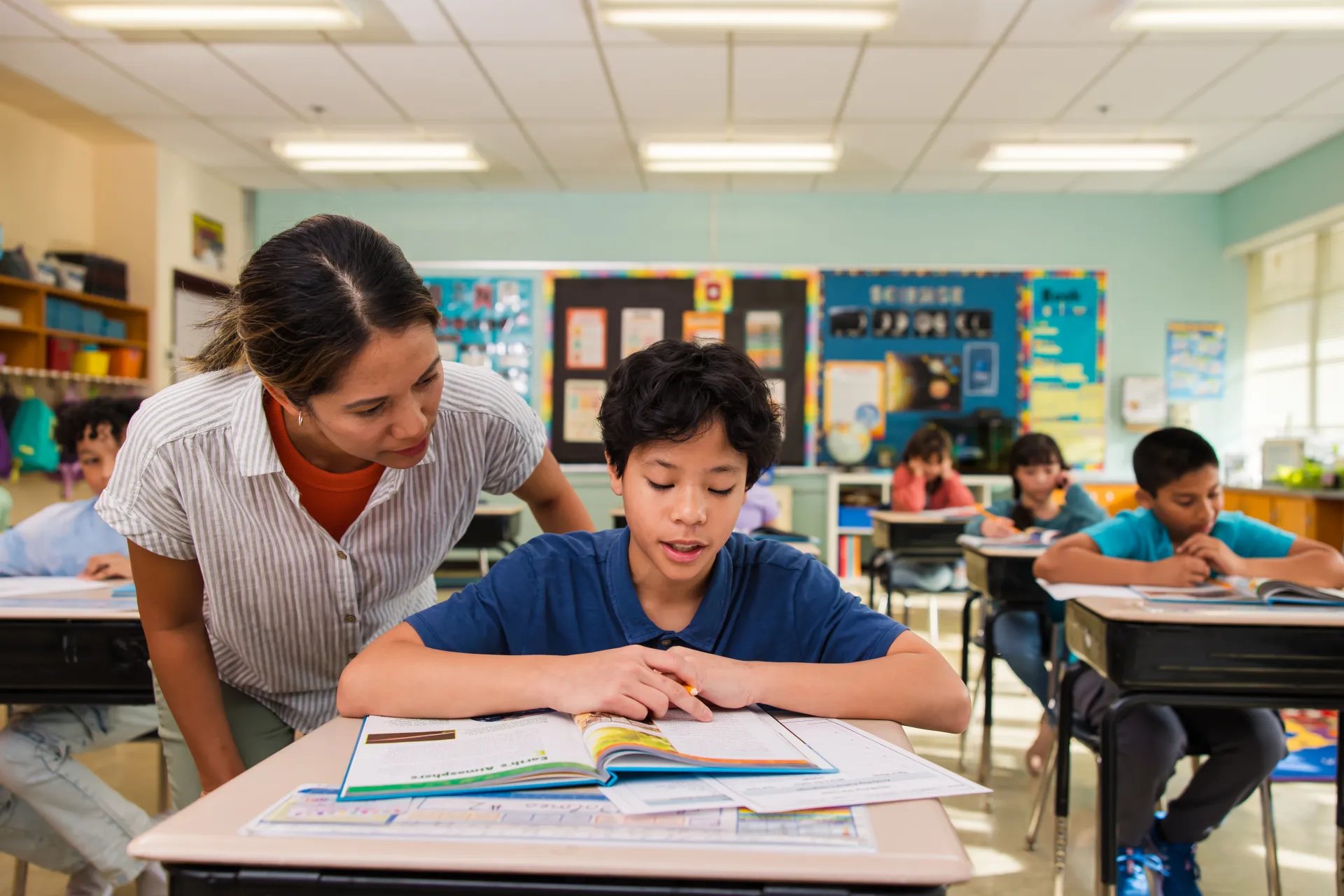 A teacher helps a student with his work.