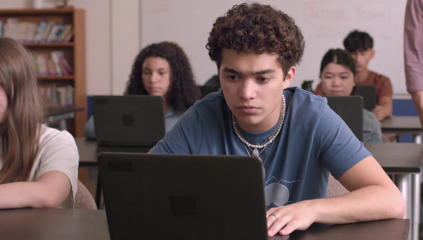 A student takes a Benchmark assessment at a computer in a classroom
